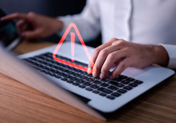 Error and maintenance concept. Businessman or it staff , programmer, developer using computer laptop with triangle caution warning sign for notification . alternate text for this image