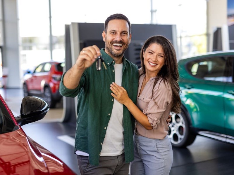 Couple buying a new car at a dealership