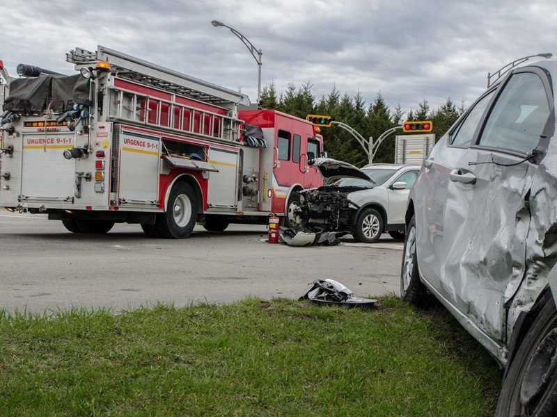 Two cars in a severe accident with a fire truck in the background