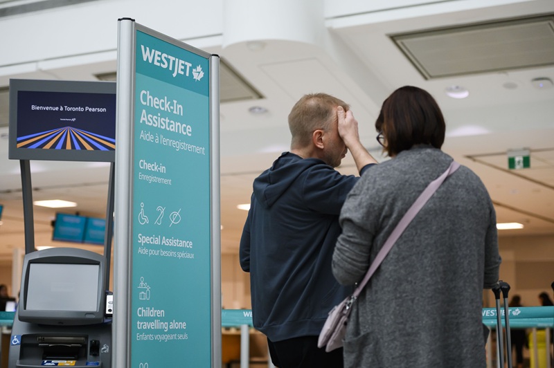 Passengers in a West Jet check-in area at Pearson Airport