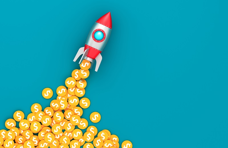 Space rocket and coins with dollar sign on blue background. Escalating costs concept