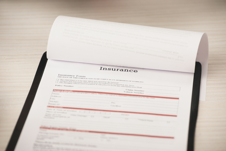 selective focus of clipboard with insurance lettering of desk alternate text for this image