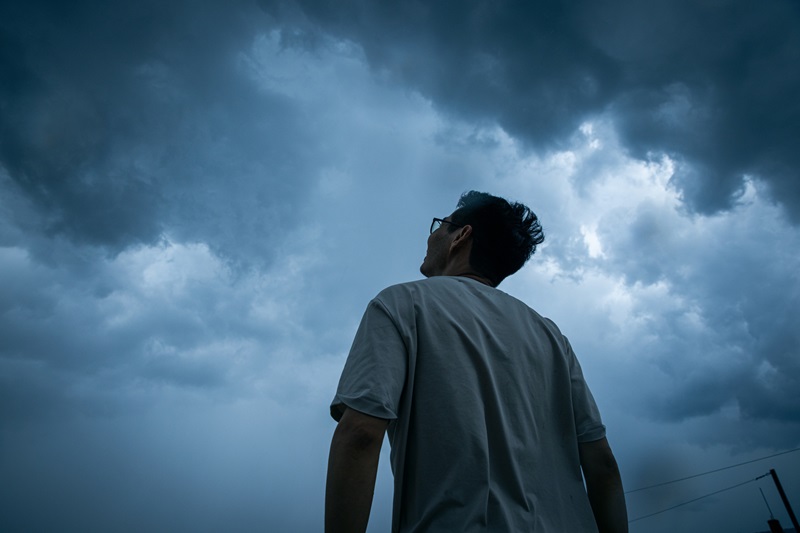 Man looking up at storm clouds forming overhead