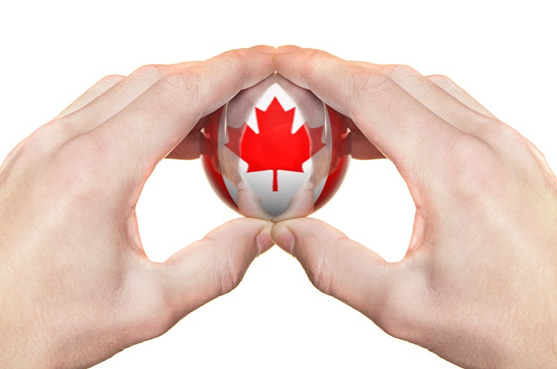 Hands holding reflective glass ball of Canada. Hand reflection on the ball. More similar images in my portfolio!