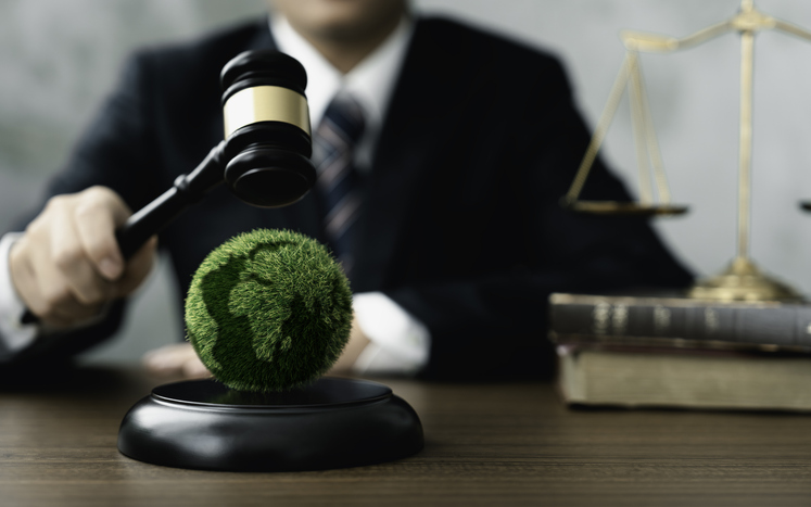 Judge hold wooden gavel with golden scale and globe for law international environmental concepts of business corporate and industry. law world environmental regulation.sustainable environment concept alternate text for this image