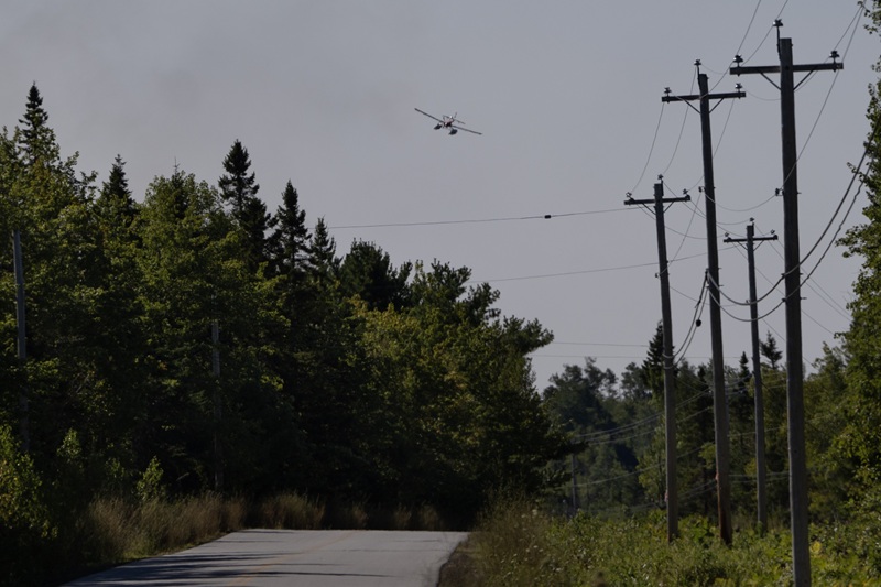 A water skimmer flies over the evacuation area near the Long Lake wildfire in Nova Scotia's Annapolis County.