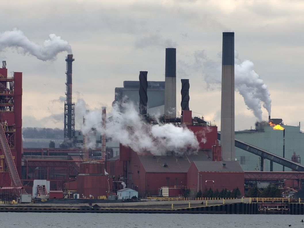 Smoke bellows from a steel mill as seen across the harbour in Hamilton, Ont.