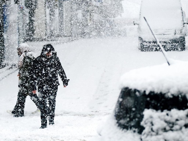 Snowfall on a street with cars