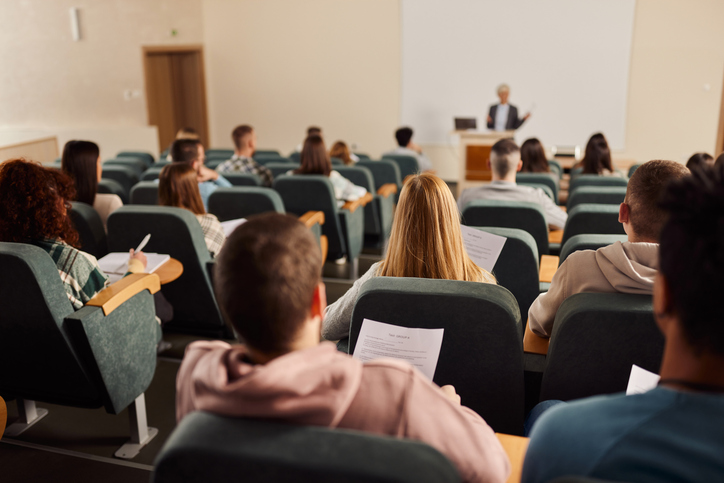 Rear view of large group of students on a class at lecture hall.