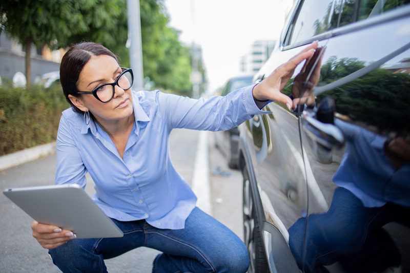 Insurance agent inspects the damage on the car