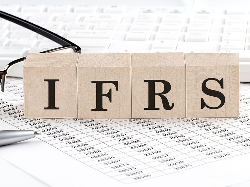 IFRS written on wooden cube with keyboard, calculator