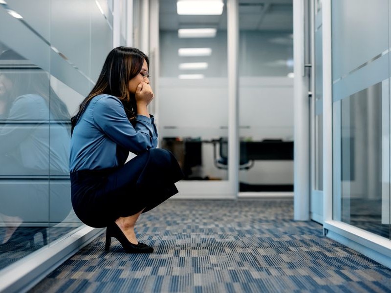 Woman in hallway overwhelmed at work