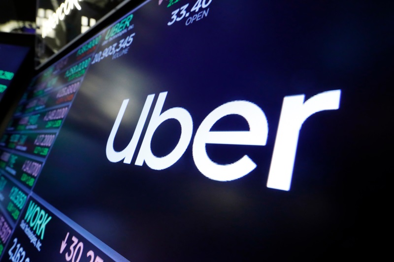 File Photo: The Uber logo appears above a trading post on the floor of the New York Stock Exchange, Aug. 16, 2019. (AP Photo/Richard Drew, File)