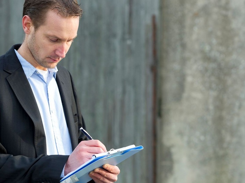 Adjuster checking damage on an old house