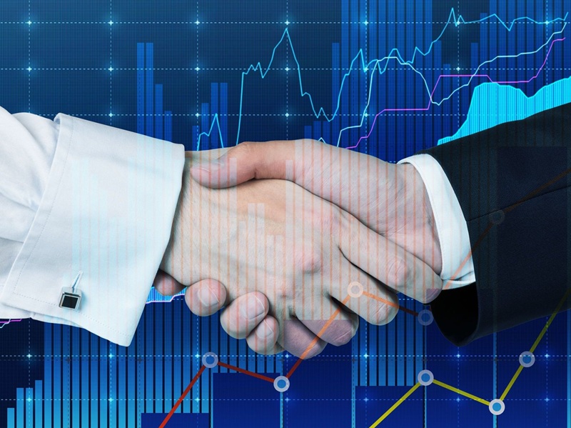 Handshake at meeting on colour charts background