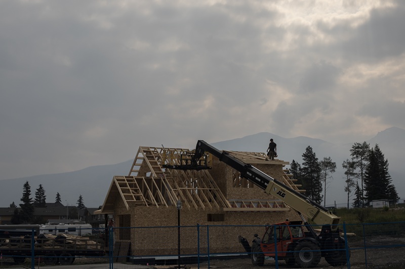Builders work a new home construction following Jasper wildfire