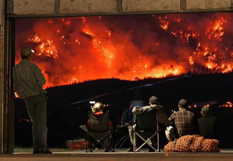 Helicopter pilots watch as a controlled fire burns on Mount McLean in an attempt to reduce the amount of fuel for a wildfire burning on the mountain in Lillooet, B.C., on Tuesday August 4, 2009. THE CANADIAN PRESS/Darryl Dyck