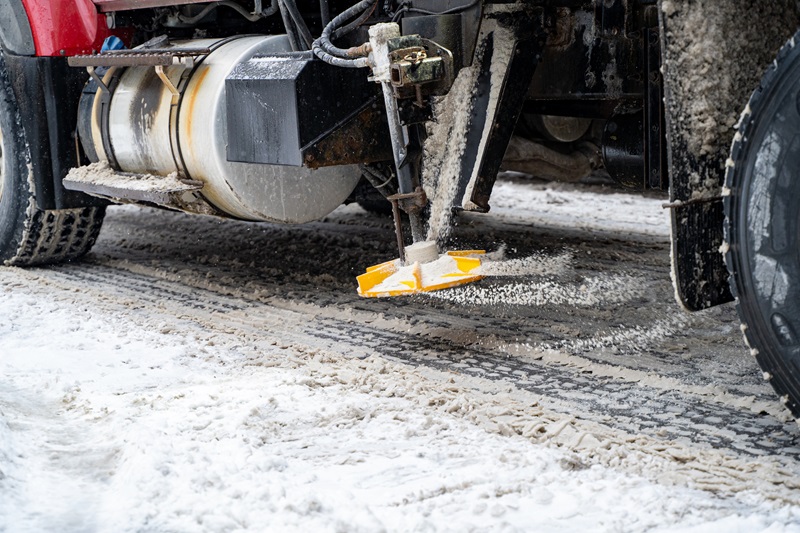 Close up of salt spreading equipment on snow plow truck during winter.